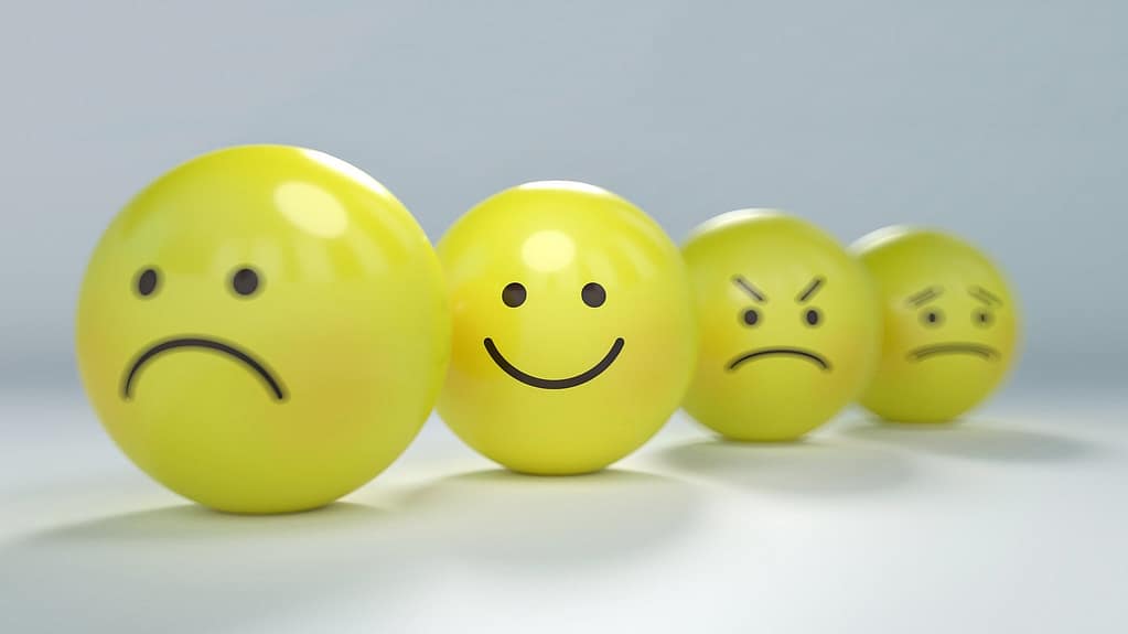 4 yellow balls the first is a simple forwning face, the second is a smiely face, the third is angry and the last is worried.